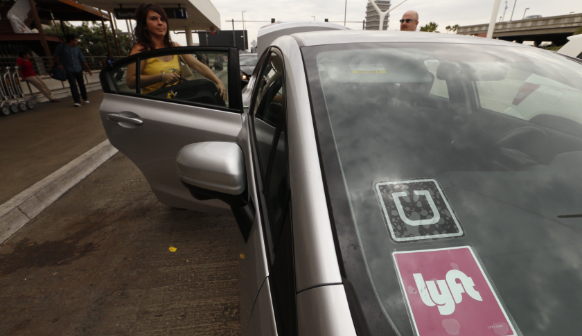 LOS ANGELES, CA AUGUST 25, 2015 -- Angela and Anthony Rodriguez, left, get a Uber Lyft ride from Tim McElearney, right, at LAX Terminal One, Tuesday August 25, 2015. After weeks of debate over the benefits and risks of embracing rapidly growing and relatively low-cost, app-based ride services, Los Angeles is poised to become the largest city in the nation to allow the start-up services to operate side-by-side with taxis, picking up and dropping passengers at the region's main air travel hub. (Al Seib / Los Angeles Times via Getty Images)
